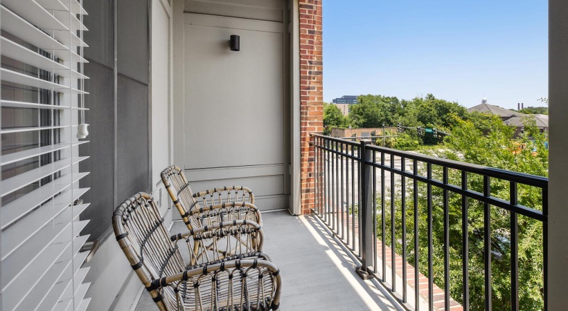 a balcony with chairs and a view