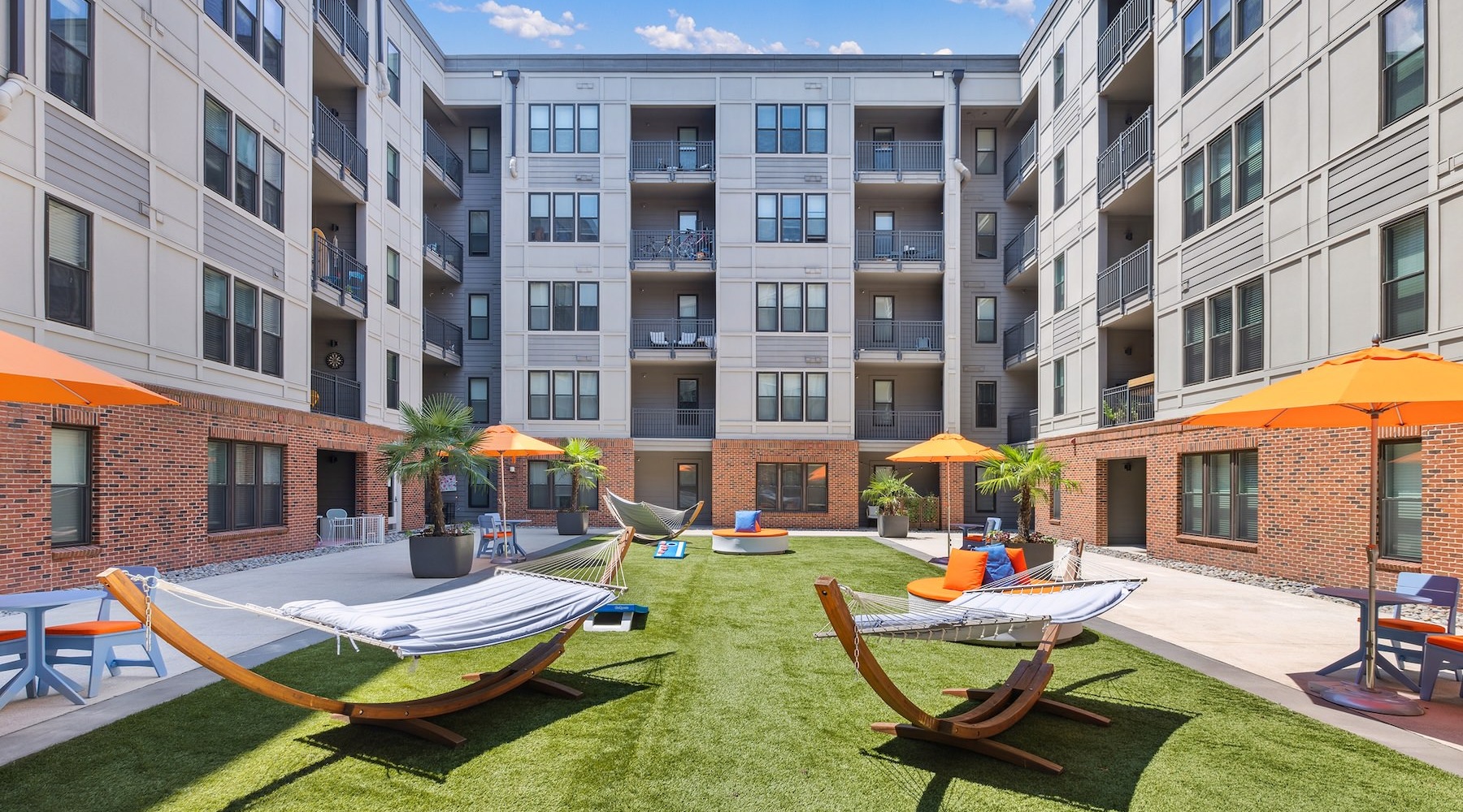 a courtyard with hammocks and umbrellas